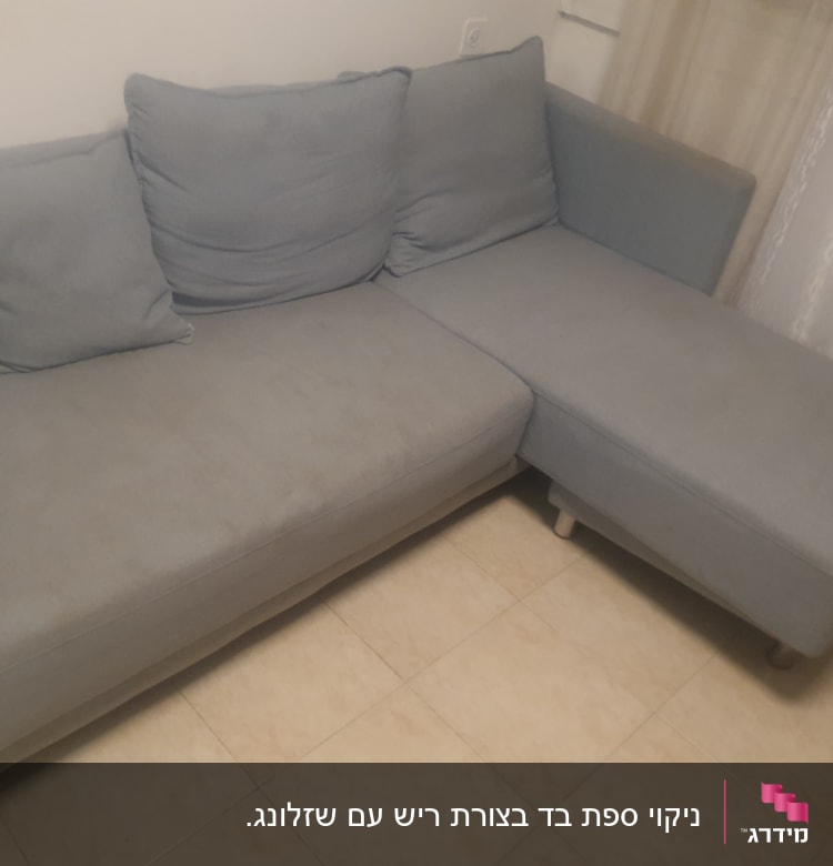 ספה אפורה עם כריות על רצפת אריחים
